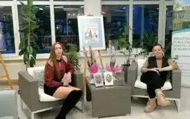 Na zdjęciu widoczne dwie Panie, kt&oacute;re siedzą na fotelach. Osoby znajdują się w pomieszczeniu. Autorka Milena Kwiatkwoska z prowadzącą spotkanie.