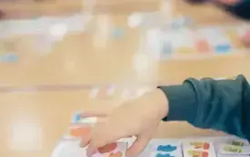 Dziecko układa puzzle z kompletem zimowych ubrań.