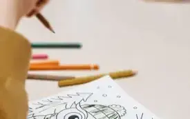 Dzieci kolorują zimowe rysunki. 