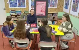 Klubowiczki siedzą przy stole z moderatorką i z uwagą słuchają wypowiedzi jednej z czytelniczek. 