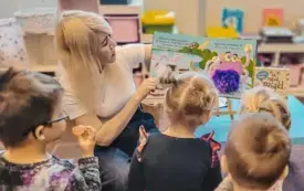 Bibliotekarka czyta dzieciom książkę o pająku.