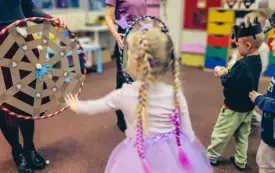 Dzieci rzucają kulki z waty do pajęczyny w hula hopie.