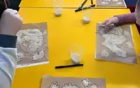 Grupa przy stole obrysowuje ryż na brązowym papierze