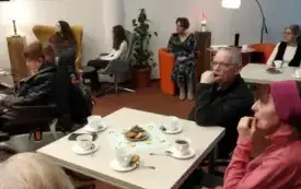 Przy stolikach siedzą osoby dorosłe, kameralne oświetlenie.