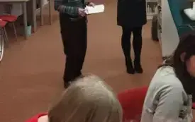 Dwie kobiety stoją, jedna trzyma mikrofon.
