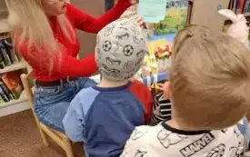 Bibliotekarka czyta dzieciom książkę o wiośnie.