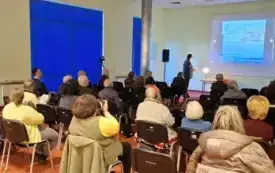 Sala pełna słuchaczy. W tle widać prelegenta, jego prezentację i baner cyklu Nowa Marchia.