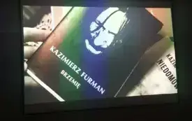 Kadr z filmu, na kt&oacute;rym znajduje się okładka tomiku poezji &bdquo;Brzemię&rdquo; Kazimierza Furmana