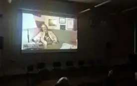 Ciemne pomieszczenie, w tle kadr z filmu o Kazimierzu Furmanie