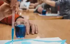 Dzieci kolorują na niebiesko kropelki deszczu.