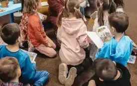 Lekcja biblioteczna 2 &ndash; Bibliotekarka pokazuje dzieciom książki.