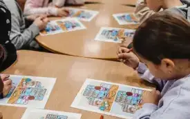 Uczniowie szukają 10 r&oacute;żnic na obrazkach z biblioteką.
