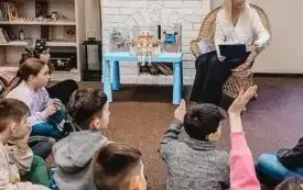 Bibliotekarka rozmawia z dziećmi.