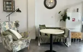 Fotel z lampą nad nim przy stoliku w przestrzeni bibliotecznej.