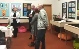 Cztery dorosłe osoby stoją na środku sali. Uśmiechają się do siebie.