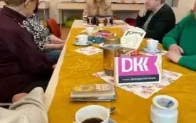 Klubowicze DKK siedzą przy stole. Trwa dyskusja. Na końcu stołu - prowadzący spotkanie.