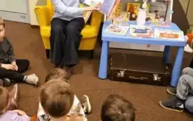 Bibliotekarka czyta dzieciom książkę. 