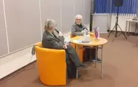 Agnieszka Kopaczyńska-Moskaluk przemawia do mikrofonu, obok niej siedzi Maciej Hen.