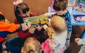 Bibliotekarka czyta dzieciom książkę. 