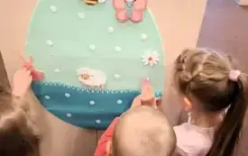 Dzieci dekorują filcowe jajko.