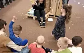 Pani Bibliotekarka czyta dzieciom książkę.
