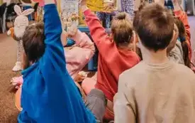 Dzieci odpowiadają na pytania bibliotekarki dotyczące przeczytanej książki.