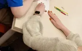 dziecko i nauczycielka przy stole wykonują zadanie