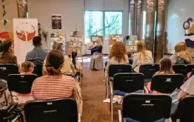 Bibliotekarka czyta dzieciom książkę o sile wyobraźni.