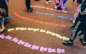 Uczestnicy spotkania układają koty według kolor&oacute;w.