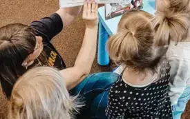 Bibliotekarka czyta dzieciom książkę.