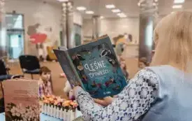 Bibliotekarka czyta dzieciom książkę.