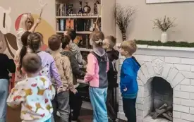 Dzieci oglądają regał z książkami o Harrym Potterze.