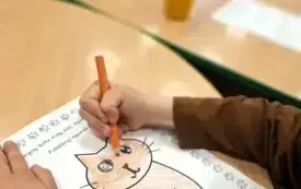 Dzieci kolorują ilustracje przedstawiające kota.