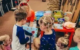 Bibliotekarka czyta dzieciom książkę.