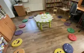 Siedziska wok&oacute;ł stolika z karteczkami w pomieszczeniu biblioteki.