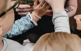 Dzieci dotykają silikonowych element&oacute;w w książeczce.