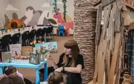Bibliotekarka czyta przedszkolakom książkę.