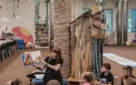 Bibliotekarka czyta dzieciom książkę.