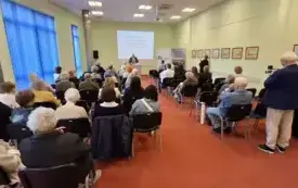 Publiczność zgromadzona w sali. Z tyłu prof. Dominik Paukszta w trakcie wygłaszania referatu.