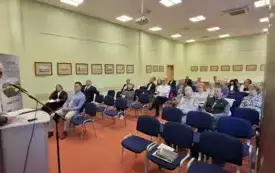Po lewej stronie przy m&oacute;wnicy prof. Arkadiusz Kalin podczas swojego referatu Po lewej zgromadzona publiczność w sali.
