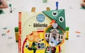 Dzieci tworzą zakładki do książek w kształcie żabek. 