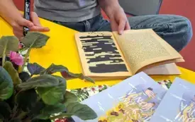 Klubowiczka tworzy blackout poetry zamalowując kartkę i zostawiając wybrane słowa.