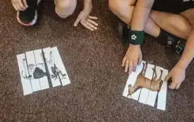 Uczestnicy spotkania układają puzzle przedstawiające zwierzęta gospodarskie.