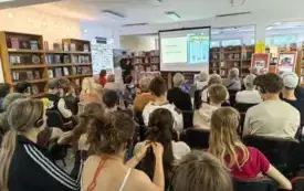 Grupa słuchaczy siedzi w rzędach.