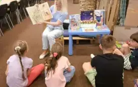Bibliotekarka czyta dzieciom książkę.