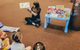 Bibliotekarka czyta dzieciom książkę.
