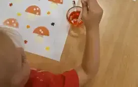 Dziewczynka koloruje muchomory.