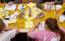grupa os&oacute;b siedząca przy stole.