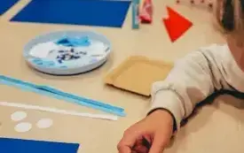 Dziewczynka przykleja plastelinę do żagla.