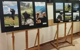 Dwie sztalugi ustawione w holu biblioteki, na kt&oacute;rych wyeksponowano fotografie.